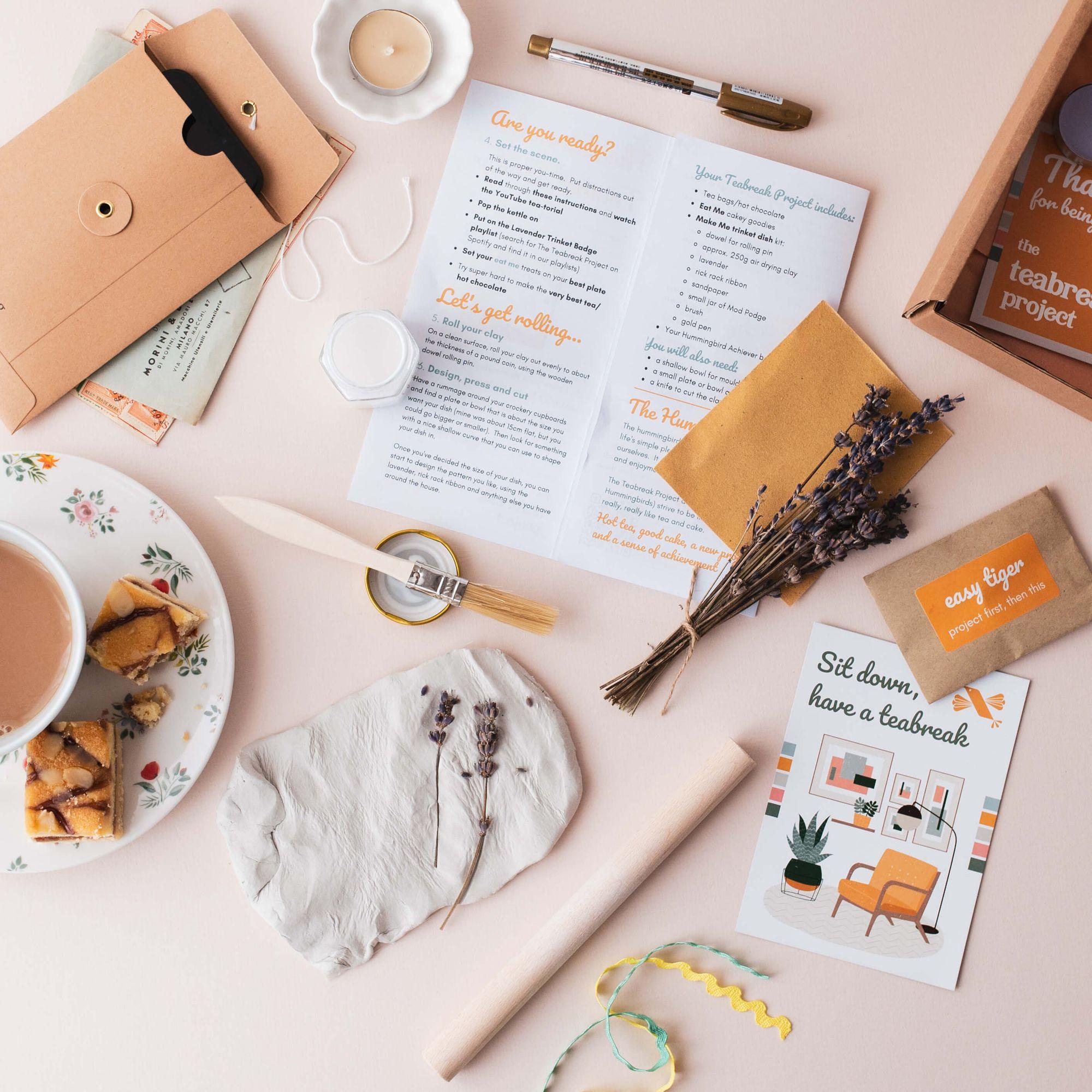 A Teabreak project laid out on an ordinary table with tea, cake, a candle and everything needed to sit down and start.