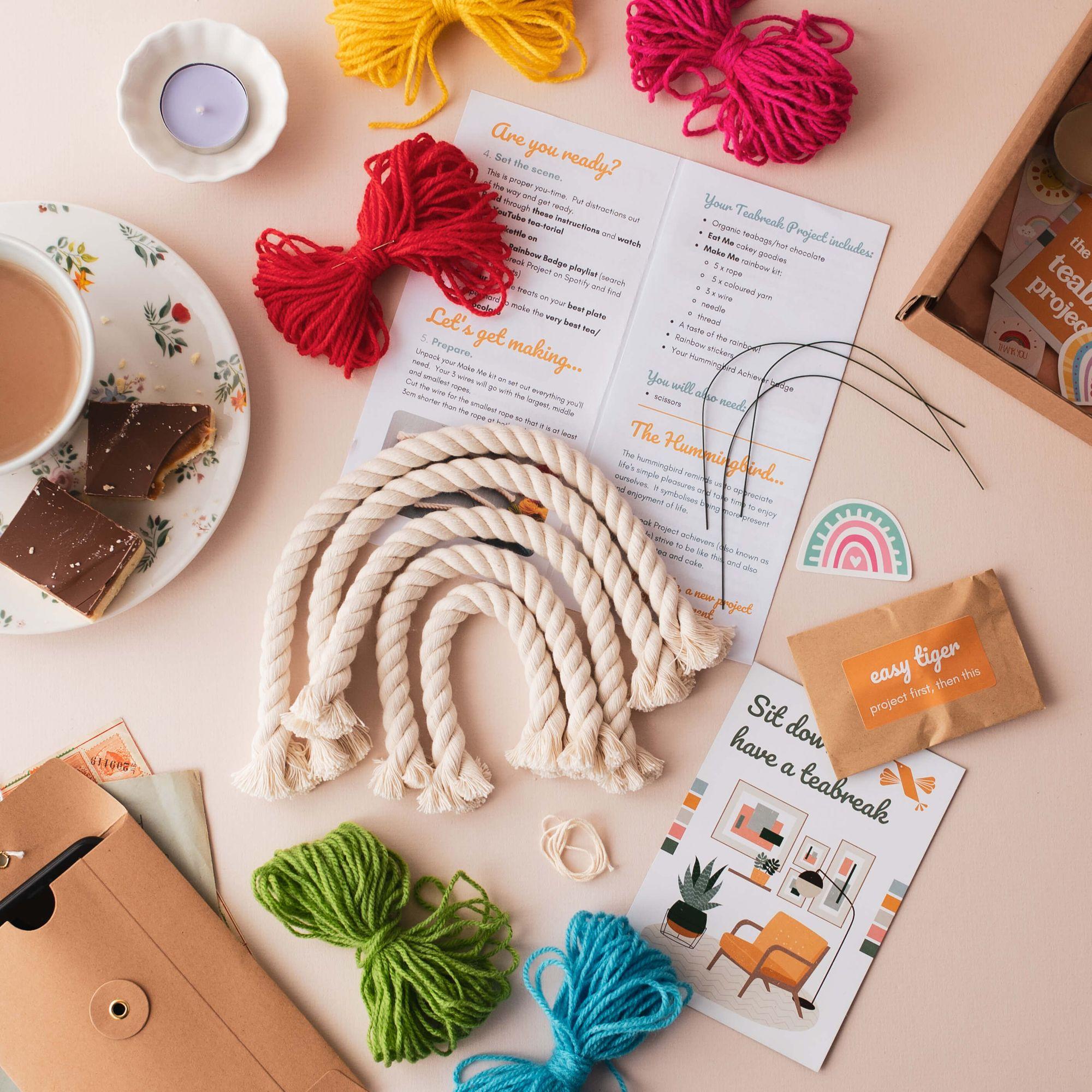Colourful yarn, a candle, tea and a creative project laid out on a worktable