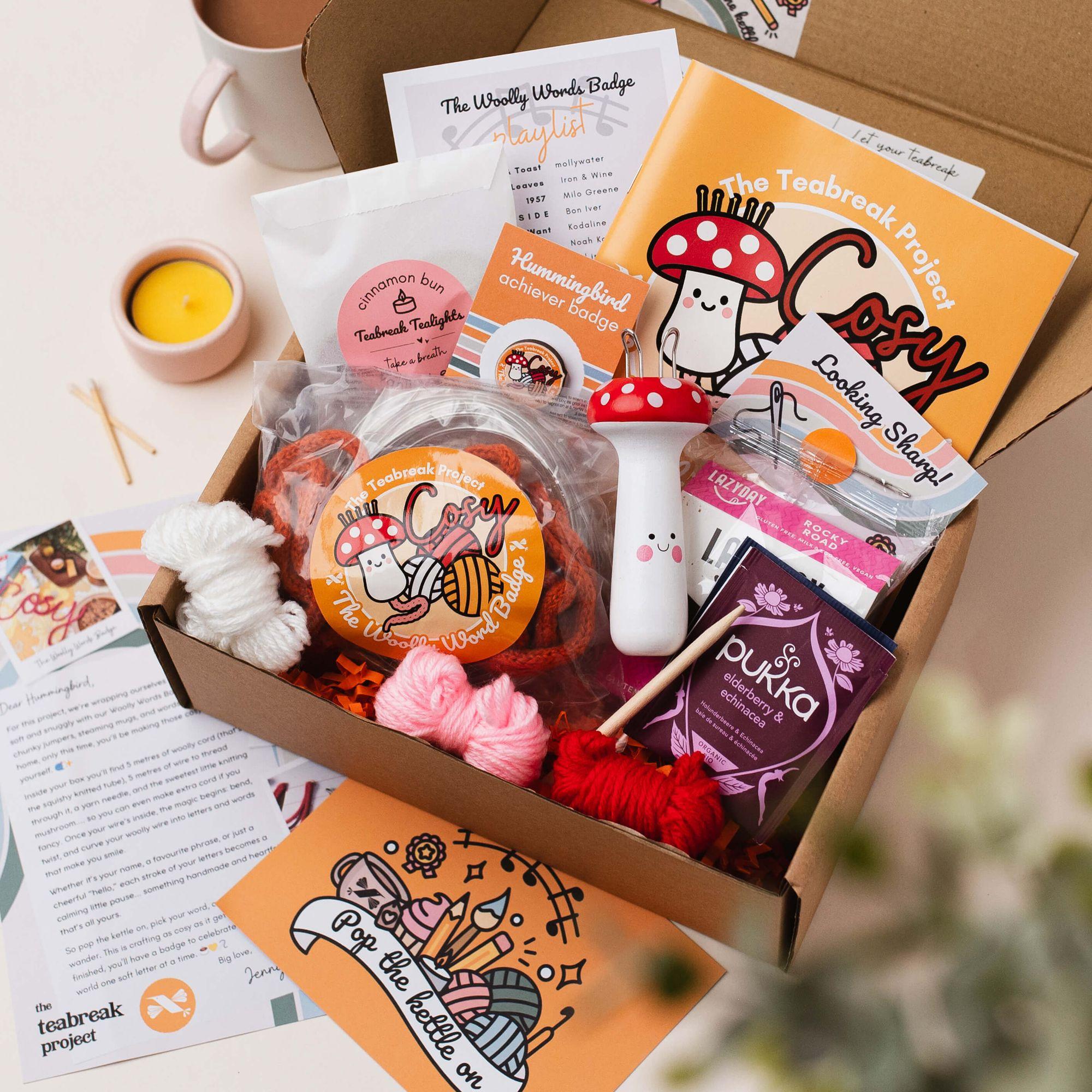 An open Teabreak box filled with a creative project, tea, treats, tealights and Hummingbird extras