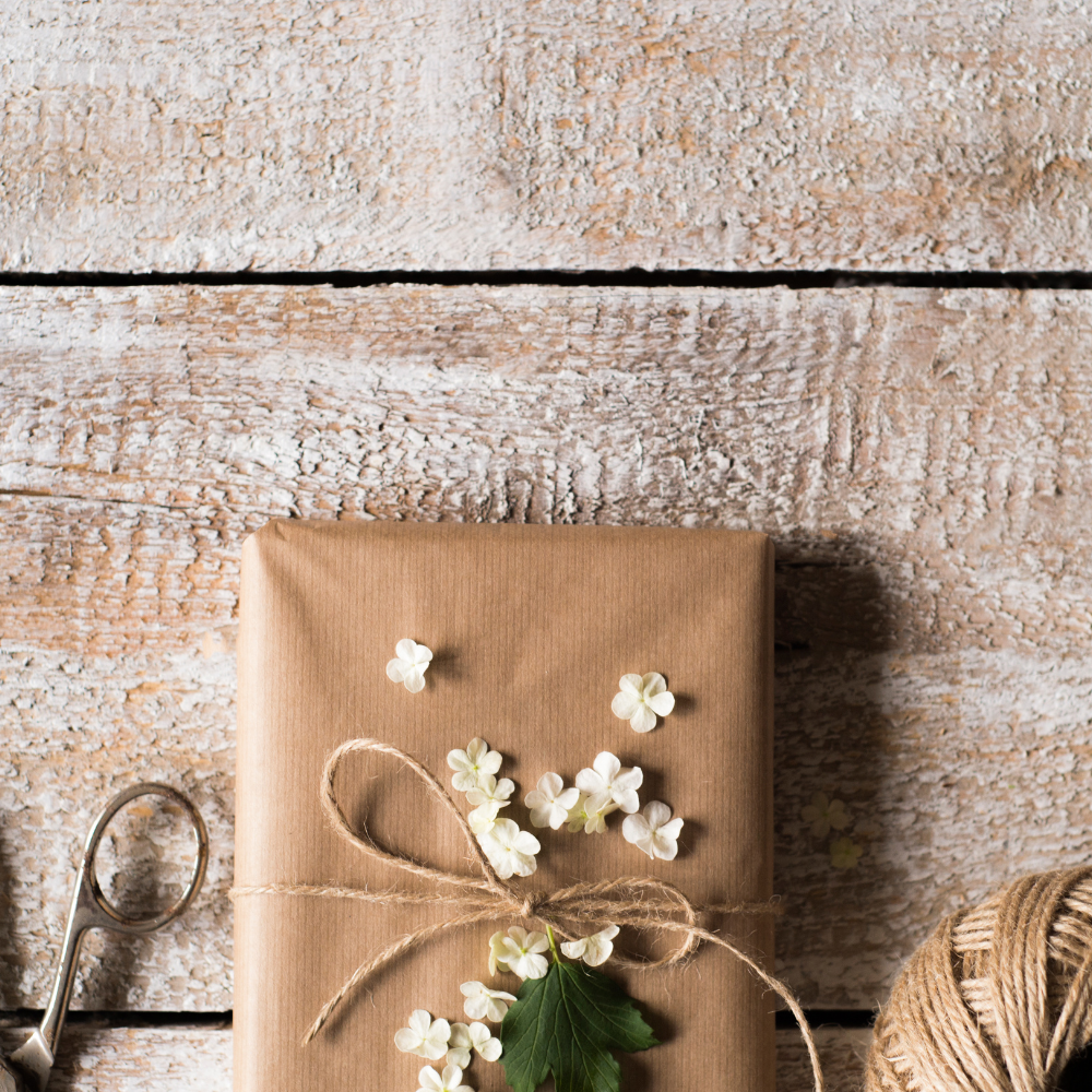 A Teabreak parcel wrapped in paper and twine, finished with a sprig of dried flowers