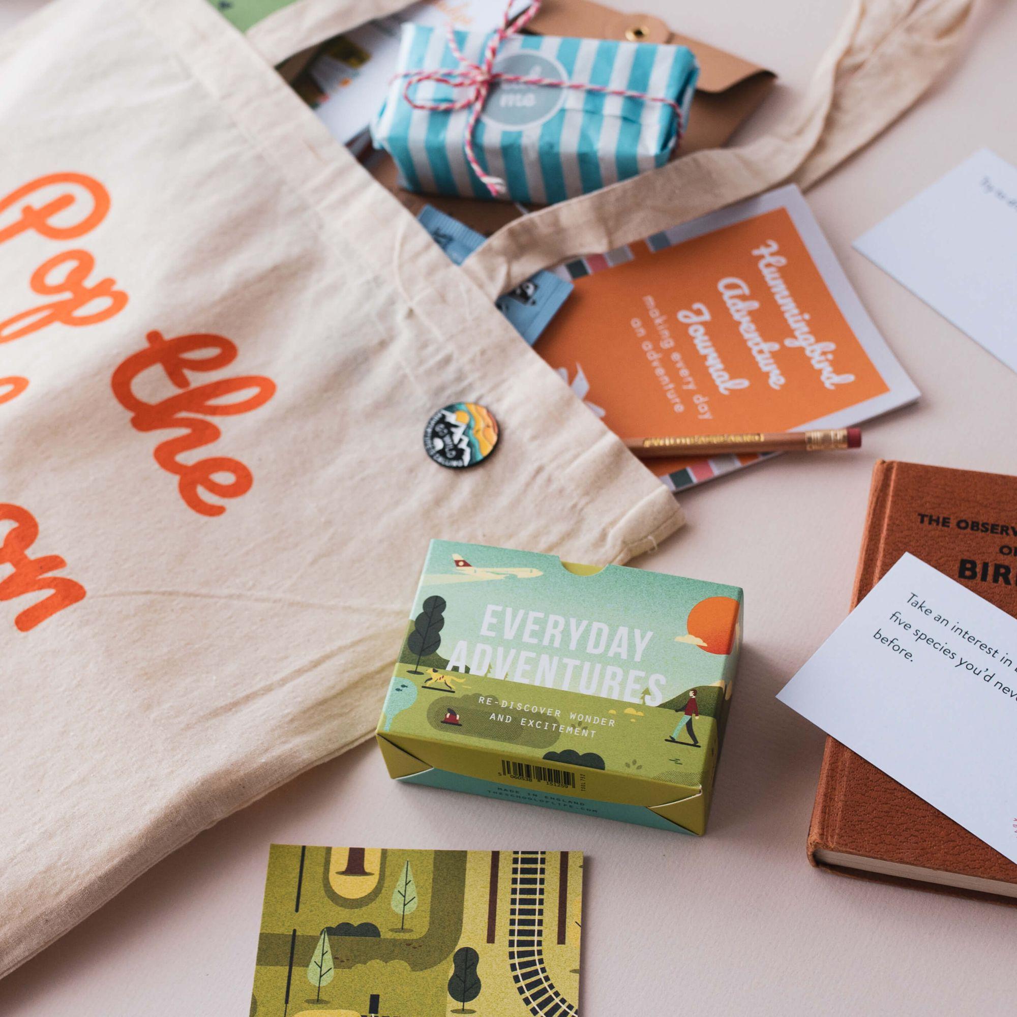 A Teabreak box laid out with a cup of tea, cake, a tealight, craft materials and project cards